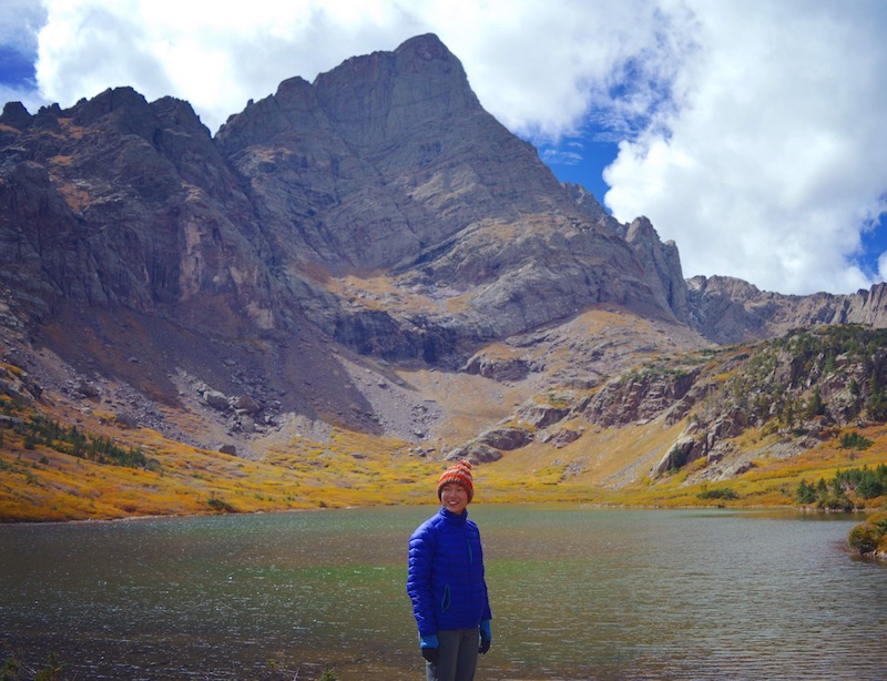 Nicole in front of a lake with Crestone Peak behind her